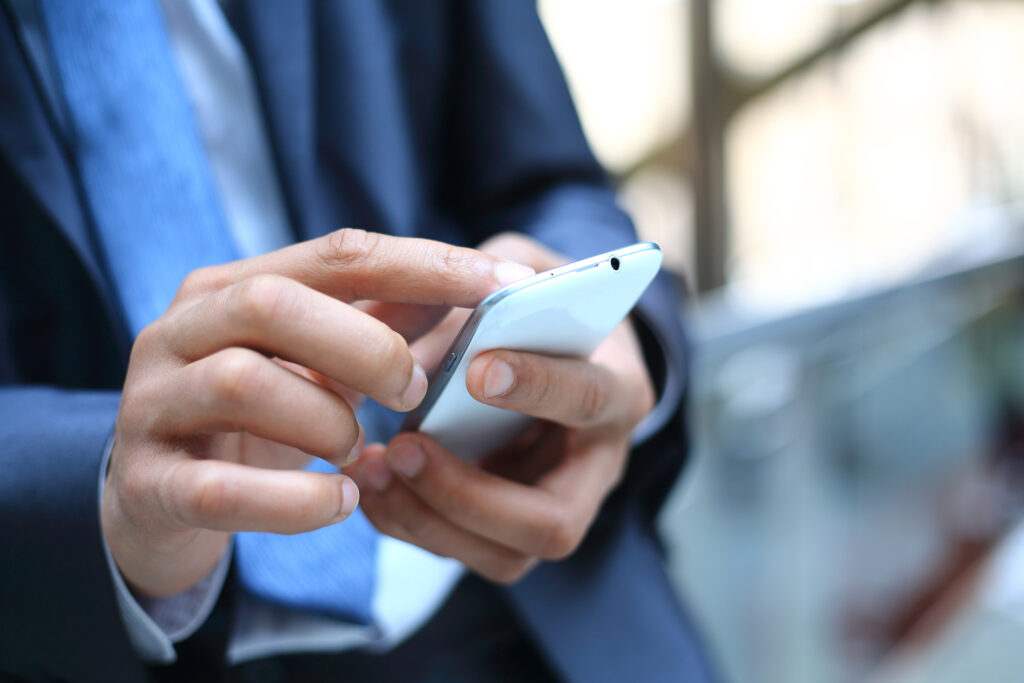 A man looking at mobile phone. Create excellent SMS marketing with CDP & CRM CareCloud